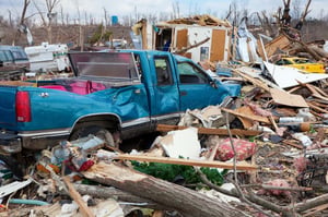 a wrecked pickup in debris from a natural disaster 
