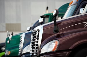 side profile of 3 semi trucks parked 