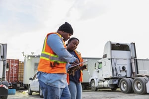 employees talking in a trucking yard