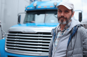 a man standing in front of a semi
