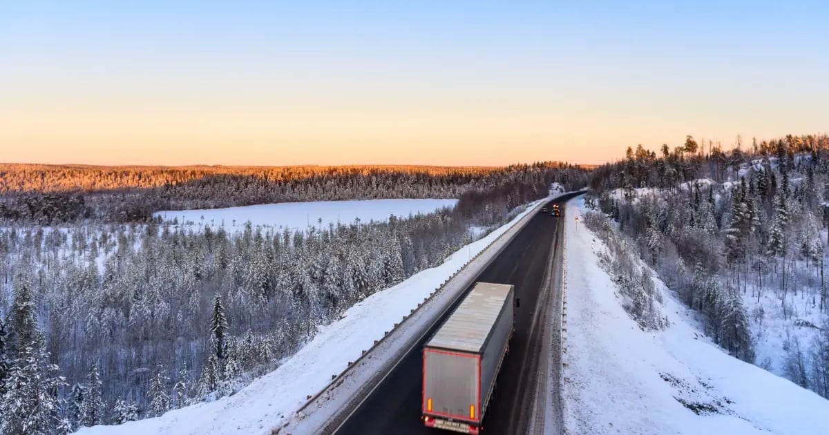 semi truck drives across a snowy road