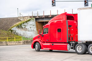 red semi making a right turn at an intersection
