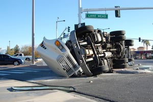 a semi crashed on its side in the middle of an intersection